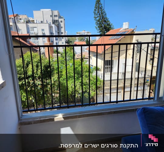 מעקה ברזל שחור במרפסת עם נוף עירוני
